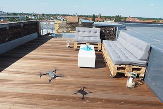 Drohnen auf der Dachterrasse bei e-pixler mit Sitzmöbeln und Blick auf die Stadt.