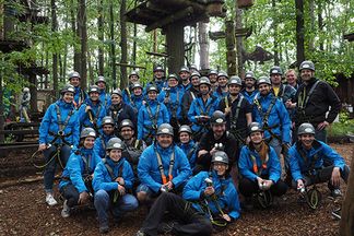 Team von e-pixler beim Sommerfest im Kletterpark, alle in blauen Jacken und Helmen.