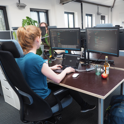 Entwicklerin bei e-pixler arbeitet an TYPO3-Projekt mit mehreren Monitoren.